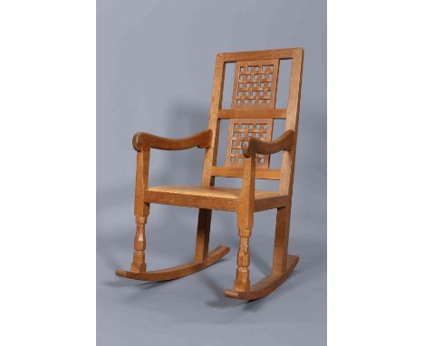 ROBERT THOMPSON OF KILBURNA MOUSEMAN OAK ROCKING CHAIR, with lattice back and tan leather seat, carved mouse signature.