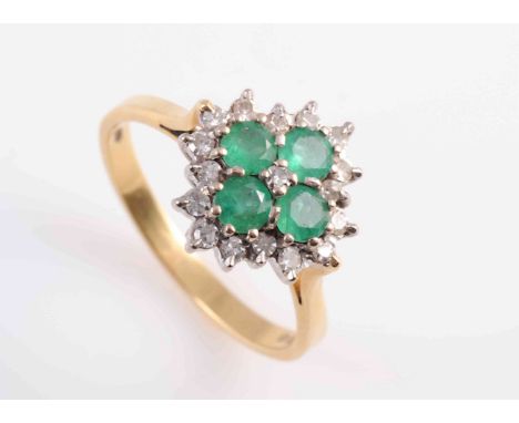 AN EMERALD AND DIAMOND RING, the four round cut claw set emeralds all set within a surround of seventeen brilliant cut diamon