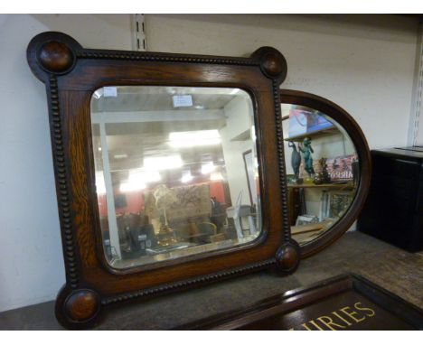 An Edward VII inlaid mahogany oval mirror and an oak framed mirror 