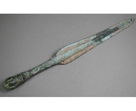 A Bronze Age shortsword, the shaped blade with thick raised midrib, with crown pommel, 41.5 cm long overall Purchasers must b