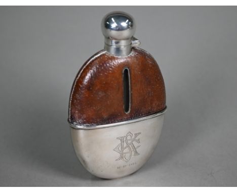 An antique glass spirit flask with leather shoulders, bayonet bun cover and detachable beaker, William Hutton &amp; Sons Ltd.