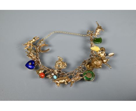 A 9ct yellow gold curb bracelet with twenty various charms attached including kangaroo, pig, cat, enamel heart, acorn, horses