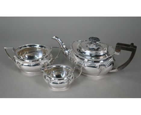 A late Victorian silver three-piece tea service with gadrooned rims and lobed bodies with fluted details, composite handle an