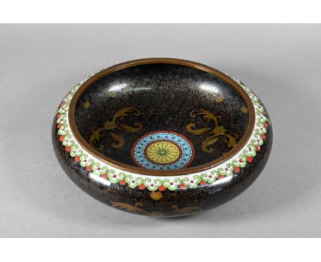 A 20th century Chinese cloisonne black ground brush washer with stylised floral design surrounding the polychrome enamel roun