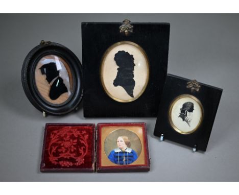 A Georgian silhouette painted under glass of a young scholar, to/w a cut-out silhouette of a lady, a painted silhouette of a 