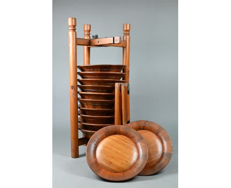 A set of twelve traditional Chinese pine plates stacked in a caddy rack carrier, 20th century, 54 cm high 