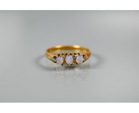 A three stone ring set circular opals, yellow metal set stamped 18ct, size R 