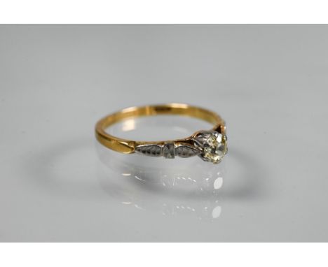 A single stone diamond ring, the claw set diamond of pale yellow hue in 18ct yellow and white gold setting with carved should