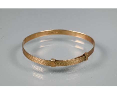 A 9ct yellow gold expanding Christening bangle with engine turned decoration, size 6cm diam (max), approx 4.1g 