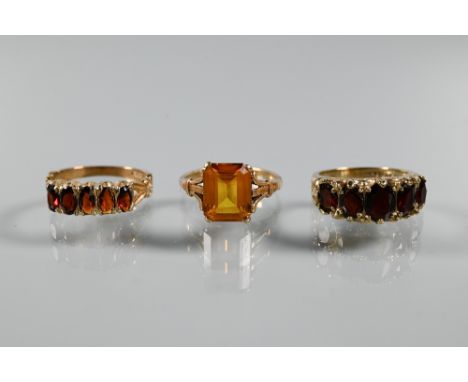 Three rings - a rectangular step cut citrine in 9ct yellow gold shank with decorative plume shoulders, size L 1/2, and two 9c