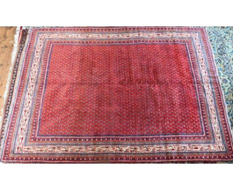 A Persian Arak carpet, the red ground with repeat all-over design of stylised boteh, 294 cm x 218 cm 