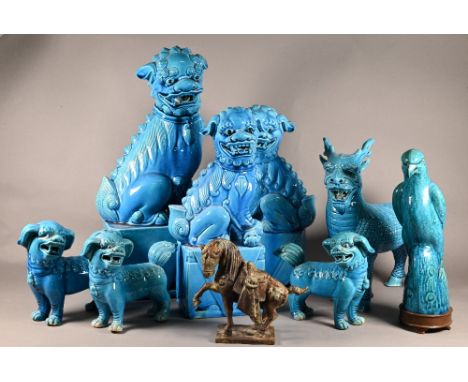 Three graduating 20th Chinese Buddhistic guardian lions on rectangular pedestal bases with bright turquoise glaze, largest 40