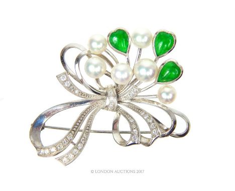 A stunning, Mikimoto, 14 ct white gold, diamond, cultured pearl and green stone brooch, composed of large, white gold bow set