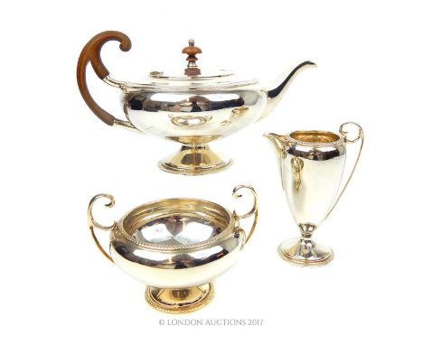 A hallmarked silver three piece tea set, John Round & Son Ltd (Joseph Ridge), Sheffield 1916, consisting of a teapot, sugar b