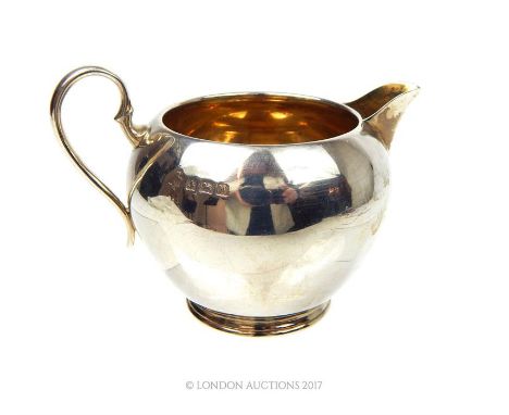 A sterling silver milk jug, William Hutton & Sons Ltd, Birmingham 1919, with gilt wash interior, 91g (2.92t oz).