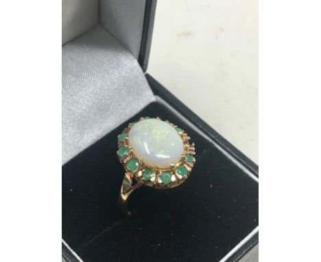 9ct gold large opal &amp; emerald ring the opal measures approx 12mm by 10mm with emerald halo weight 3.7g missing small emer