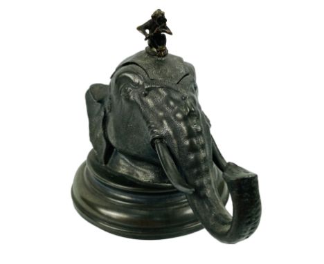 An early 20th century silver plated novelty inkwell in the form of an elephant head with a monkey on his head playing a music