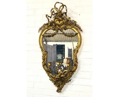 A 19th century giltwood cartouche shaped girandole with extensive carved decoration throughout, 53cms wide x 104.5cms high. E