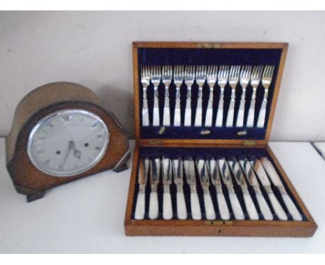 An Edwardian oak mantel clock together with an oak canteen of fish cutlery 