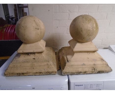 A pair of concrete pillar caps.