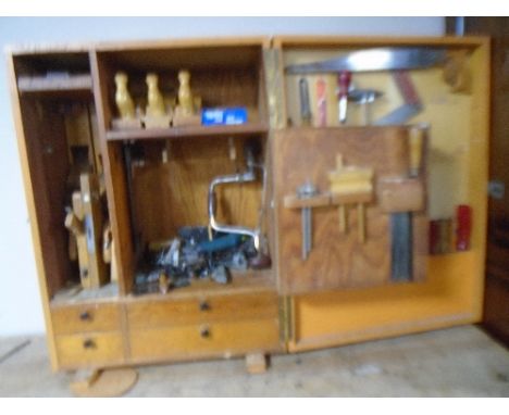 A 20th century painted pine workshop cabinet containing an assortment of hand tools including spirit levels, molding planes, 