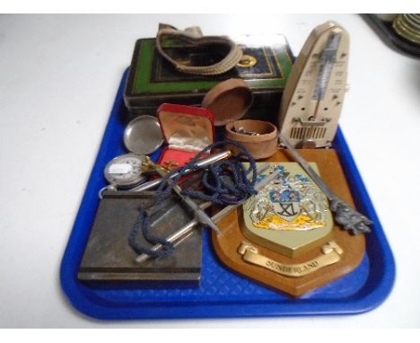 A tray containing pocket compass, cufflinks, tuning forks, metronome, opera and field glasses.