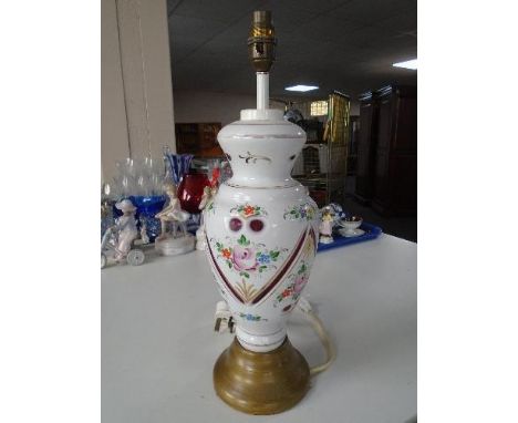 An opaque glass table lamp with floral decoration on red ground 