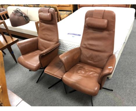 A pair of 20th century Danish BD Mobel furniture brown leather high backed armchairs with head rests and matching footstool, 