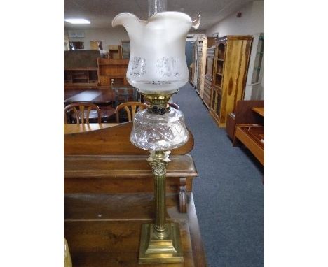 A Victorian glass oil lamp on Corinthian column base with clear glass reservoir and opaque glass shade 