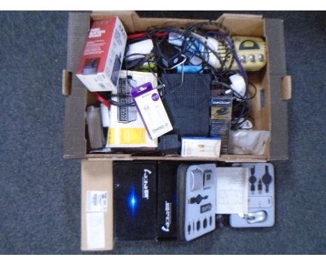 Two boxes containing clock radios, charging cables, Freeview box, professional car speakers, timer switches etc.