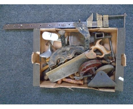 A box of vintage tools including a large vice, shoe lasts, saws etc.