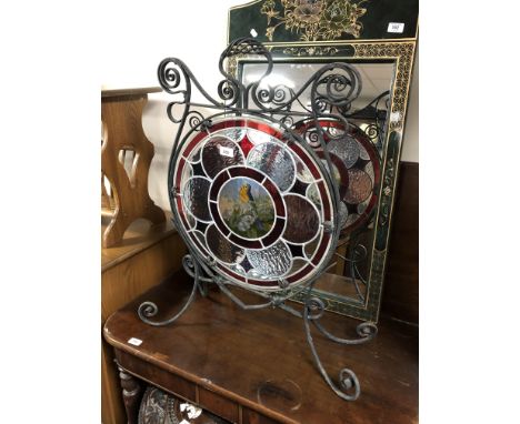 A 19th century wrought iron fire screen with a stained leaded glass panel.