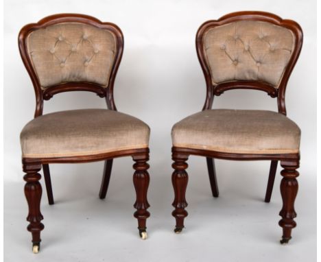 A pair of early 20th century hall chairs with upholstered seat and button backs on turned and fluted legs and ceramic casters