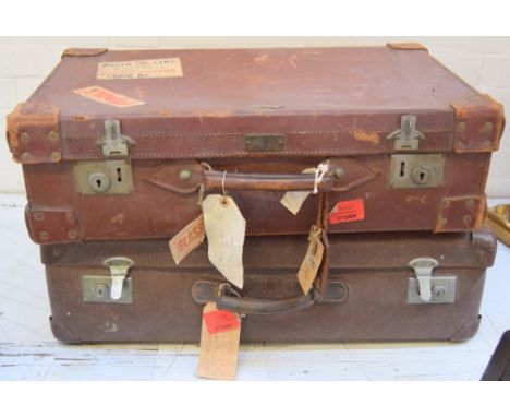 A vintage brown gentleman's suitcase with associated travel labels including 'Booth Line - Round Voyage' with one other
