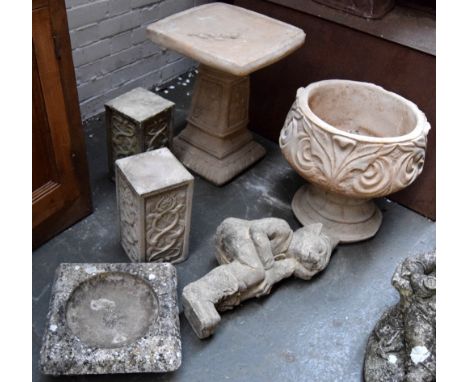 A composite planter with decoration, a composite bird bath on plinth, two decorative plinths, together with a seated garden g