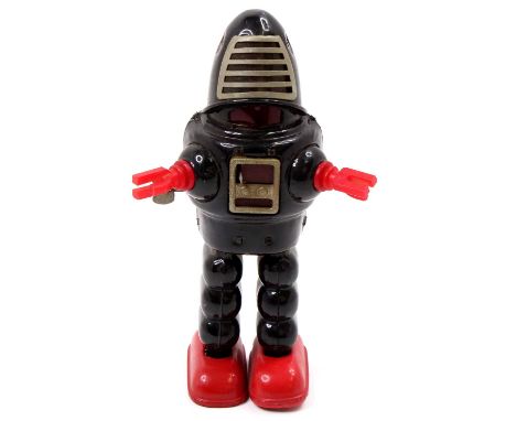 A KO Toys of Japan tinplate and clockwork planet Robbie the Robot, comprising of a black body with red hands and red feet, si