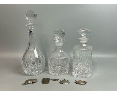 Three crystal decanters one by Edinburgh Crystal and four metal bottle labels one stamped silver, all decanters in good condi
