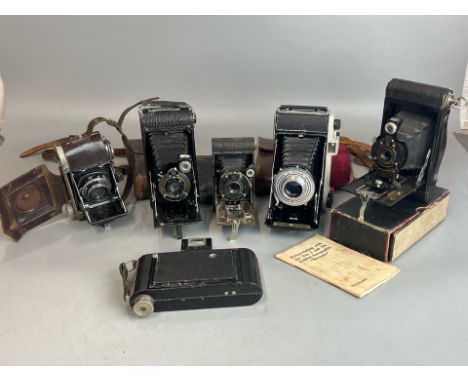 Six vintage folding cameras including Kodak Brownie no.2 with box and manual, Kodak Sterling II, Kodak "Vest Pocket" model B,