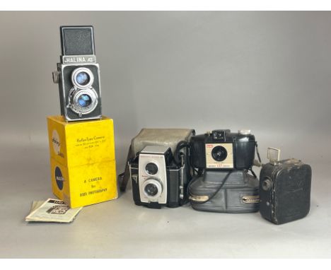 Four vintage cameras including aq Pathe "Baby" cine-camera, Halina A1 with original box and manual, Kodak Brownie Reflex 20 a