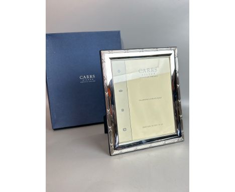 A brand new boxed Carrs hallmarked silver photo frame 10" x 8" with ribbon and reed border and blue velvet back. Hallmarked S