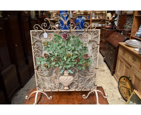 An old painted wrought iron firescreen.