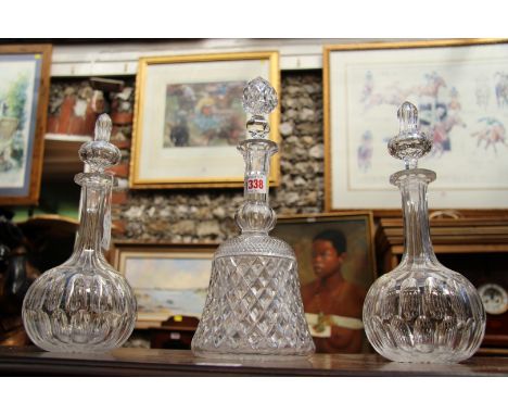 A pair of decanters and stoppers; together with another decanter and stopper.  