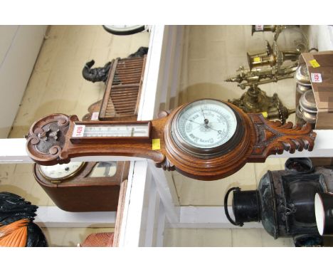 A carved oak aneroid wheel barometer; together with an oak mantel clock. 