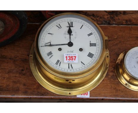 A Sestrel brass bulkhead style clock, 20.5cm diameter; together with another similar smaller aneroid barometer. 