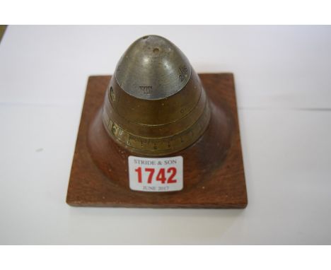 A Trench Art paperweight, inscribed to the base 'made of German shell & oak from Ypres Cathedral'.