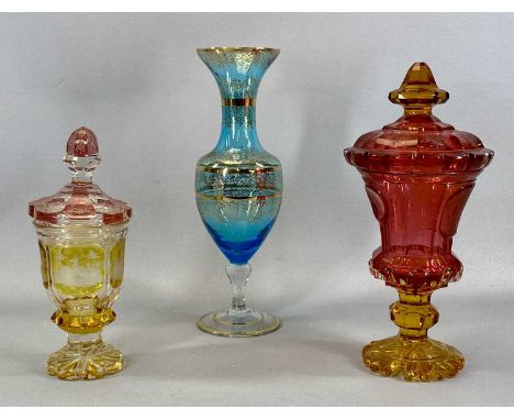 TWO BOHEMIAN COLOURED GLASS POKALS with covers, one etched with hunting scenes, 26cms (h), the other etched with flowers, 32c