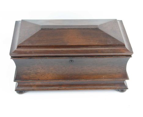 A large early Victorian rosewood tea caddy, of sarcophagus form, the hinged cover opening to reveal a central cut glass mixin