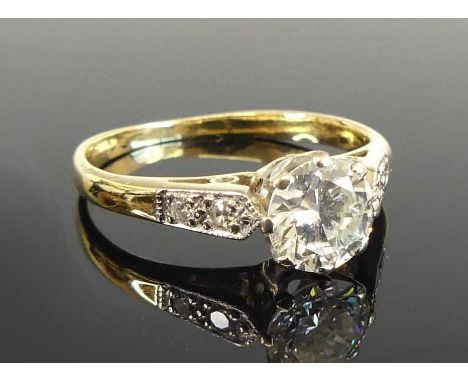 An Art Deco diamond solitaire ring, featuring a round brilliant cut diamond in an eight-claw setting, with two round brillian