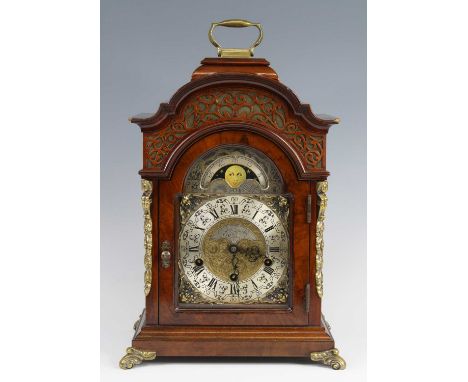 A George III style walnut cased bracket clock, the arched dial having silvered chapter ring with inner Roman and outer Arabic