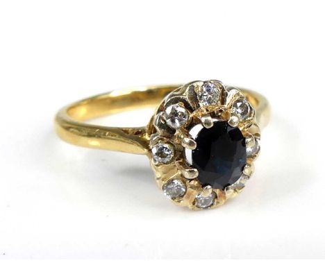 An 18ct gold sapphire and diamond oval cluster ring, featuring a centre sapphire within a border of eight round brilliant cut
